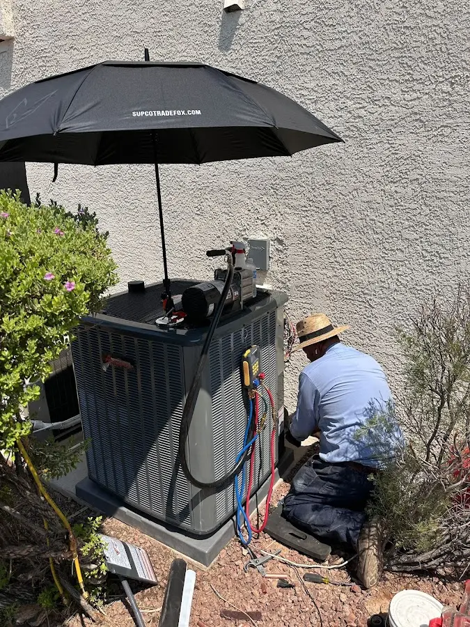 HVAC technician performing outdoor AC maintenance in Keene