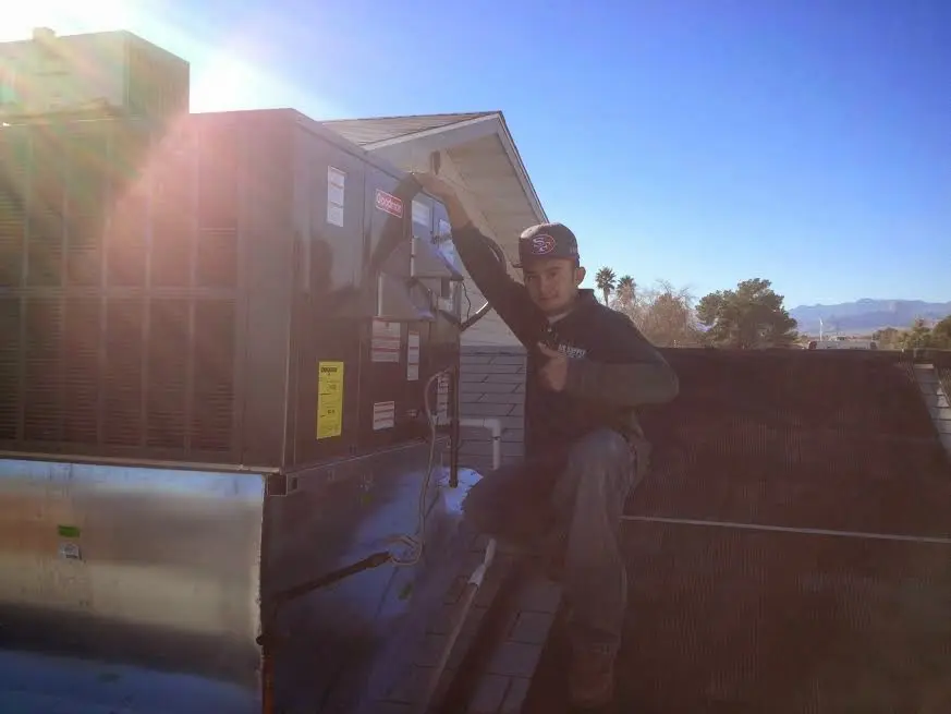 HVAC technician performing AC Tune-Up on a rooftop unit in Keene